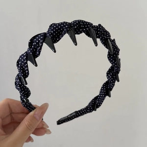 Detailed view of navy blue polka dot headband with woven knot and anti-slip inner teeth