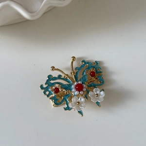 Detail der Schmetterlings-Haarklammer mit blauen Emaille-Flügeln und Blumen-Quasten