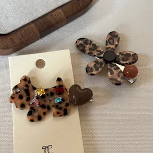 Detail of leopard print dog and flower hair clips with colorful rhinestones and beads
