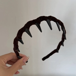 Detail showing brown velvet headband texture and black non-slip plastic inner teeth