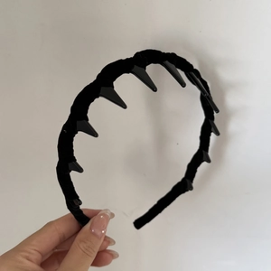 Detail of black velvet headband showing inner plastic teeth for non-slip grip