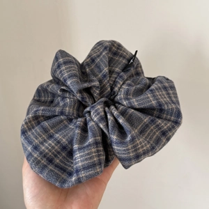 Detailed view of large blue and grey plaid wool scrunchie with soft fabric texture