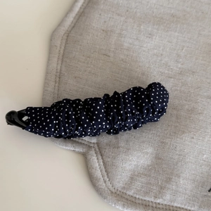 Navy blue polka dot pleated banana hair clip with secure plastic base for women