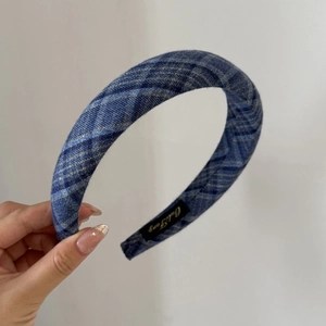 Detailed view of padded blue plaid headband showing thick sponge texture and fabric weave