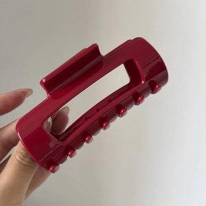 Nahaufnahme einer großen burgunderroten Silikon-Haarklammer mit hohlem rechteckigem Design