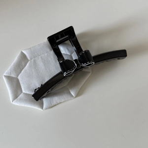 Détail d'une pince à cheveux à nœud papillon noir avec bordure piquée blanche élégante