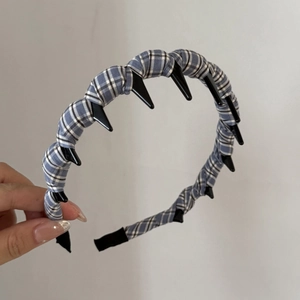 Détail d'un serre-tête en tissu à carreaux bleu et blanc avec des dents antidérapantes