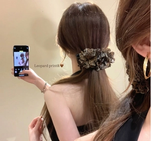 Rear view of a model wearing the leopard print banana clip with ruffled chiffon fabric
