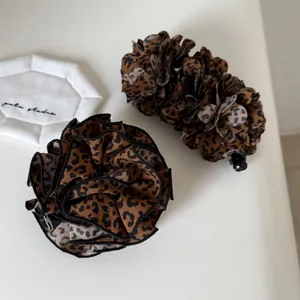 Macro detail of vintage leopard print banana clip and scrunchie hair accessory set
