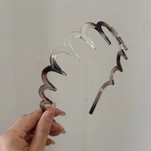 Détail d'un serre-tête ondulé en acétate avec dents antidérapantes et dégradé gris