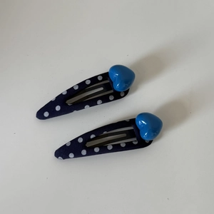 Pair of navy blue polka dot fabric hair clips with blue heart decoration for girls