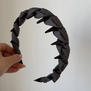 Détail d'un serre-tête en tissu gris foncé avec des dents pointues noires antidérapantes