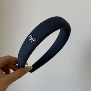 Detailed view of navy blue denim padded headband with silver metal bow and rhinestone