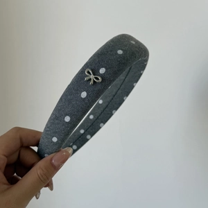 Detail of grey denim polka dot padded headband with silver rhinestone bow buckle