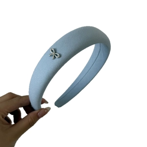 Light blue denim padded headband with silver metal bow and small rhinestone detail
