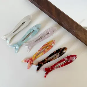 Set of colorful fish-shaped acetate hair clips featuring pearlescent and marbled patterns