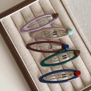 Set of five matte metal oval BB hair clips with contrast heart charms in varied colors