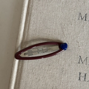 Navy blue heart cutout BB clip hair accessory on vintage book background