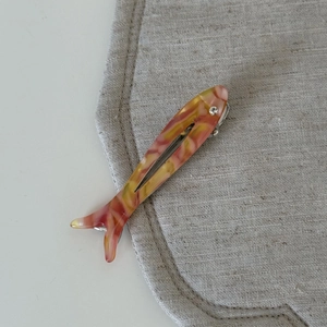 Detail of cute fish hair clip with red and yellow marble texture and rhinestone eye