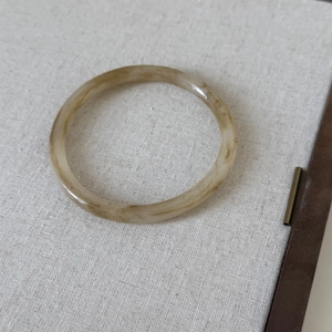 Detailed macro view of retro acrylic resin bangle with marble texture and smooth finish
