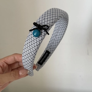 Detail of checkered padded headband with black ribbon bow and turquoise bead decoration