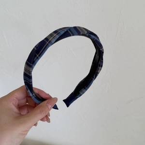 Detail of plaid headband showing blue and grey fabric texture with non-slip inner teeth