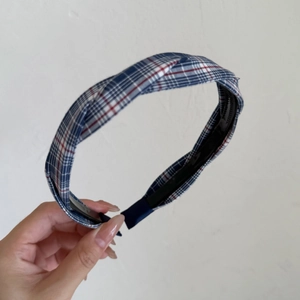 Close-up of blue and red plaid crossover headband with anti-slip teeth for secure styling