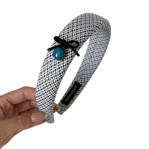 Retro black and white checkered thick headband with green bead and bow decoration