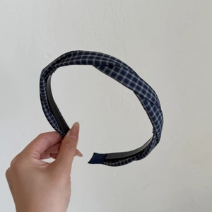 Close-up of blue and white plaid cross knot headband with anti-slip inner teeth