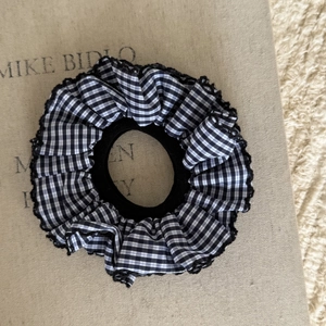 Vista dettagliata dell'elastico per capelli a quadretti blu navy con pizzo e volant