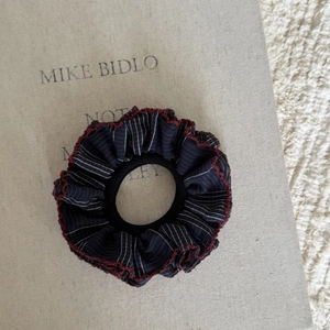 Dettaglio elastico blu navy con strisce bianche e cucitura ondulata rossa