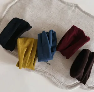 Close-up detail of premium velvet scrunchies set in various colors with soft fabric texture