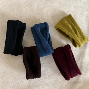 Velvet elastic hair scrunchies set in five colors on a textured beige background