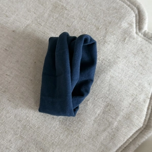 Detailed view of dark blue velvet fabric texture and soft knit scrunchie material