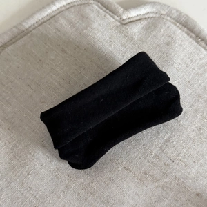 Detailed view of the premium black velvet fabric texture on the elastic hair scrunchie