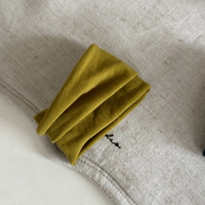 Macro detail of the premium velvet hair tie texture in olive green and mustard yellow