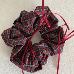Plaid scrunchie in red and black pattern with ribbon details for elegant hairstyles
