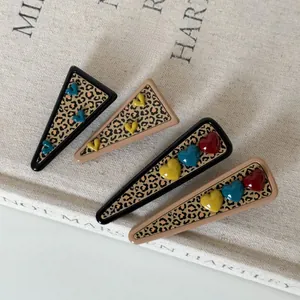Detail of leopard print hair clips with colorful 3D heart charms in a four-piece set
