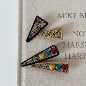 Leopard print hair clips with colorful 3D heart shapes in black and khaki frames
