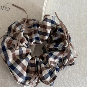 Detail of coffee plaid scrunchie with satin bows and vintage checkered pattern