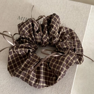 Detailed view of brown plaid hair scrunchie with delicate dark satin ribbon bows
