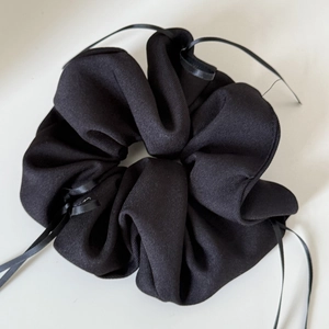 Detail of black textured cotton scrunchie with long satin ribbons for ballet style