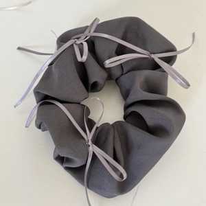 Detail of dark grey ballet-style hair scrunchie with cute satin ribbon bows decor