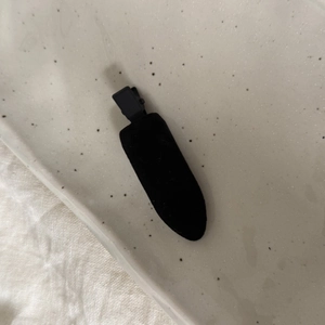 Vue détaillée de la texture en velours noir et du clip bec de canard de cette barrette chic
