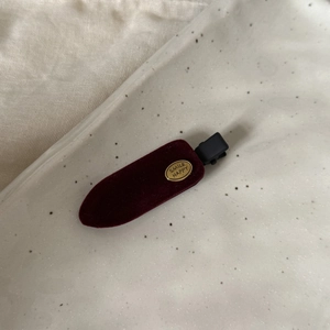 Détail de la barrette en velours bordeaux avec plaque métallique dorée Smile Happy
