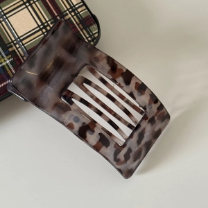 Detail view of square flat leopard tortoise claw clip with smooth glossy acetate finish