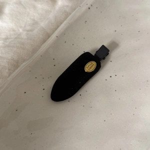 Détail d'une barrette en velours bleu avec une plaque dorée gravée SMILE HAPPY élégante