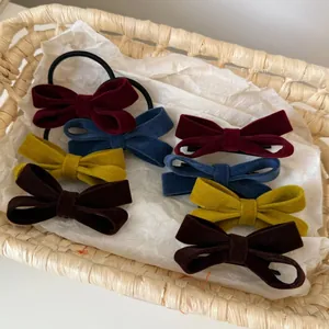 Detailset aus Vintage-Samtschleifen-Haarspangen und Gummis in Weinrot, Marine und Braun