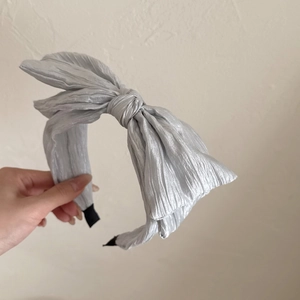 Elegant silver grey pleated bow headband with a metallic satin finish for women