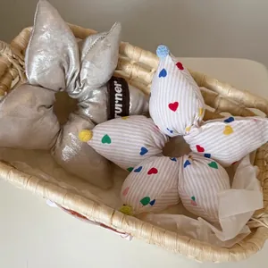 Silver padded star scrunchies and colorful heart pattern hair ties in a straw basket